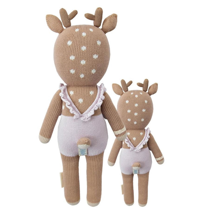 Back view of two knitted deer dolls, large and small, showing the lavender romper with ruffled straps and little tails.
