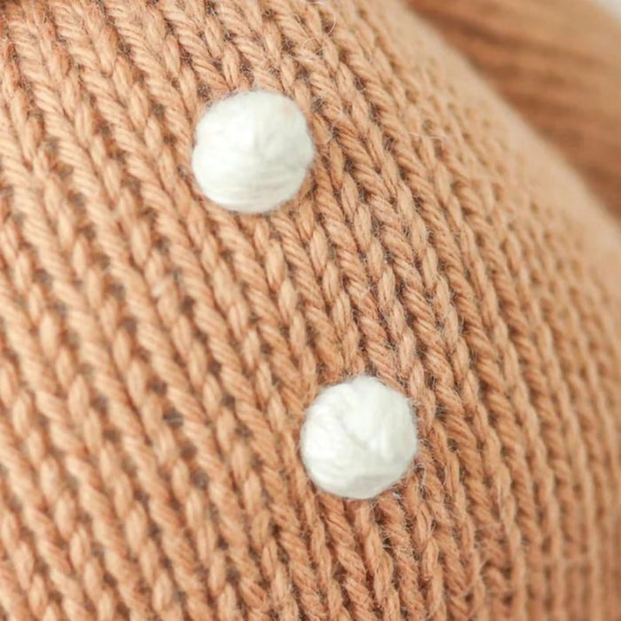 Detail of white embroidered buttons on Cuddle + Kind Baby Gingerbread Doll – White Icing.