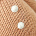 Detail of white embroidered buttons on Cuddle + Kind Baby Gingerbread Doll – White Icing.