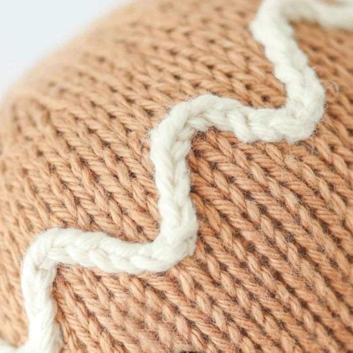 Close-up of white icing detail on hand-knit Cuddle + Kind Baby Gingerbread Doll.