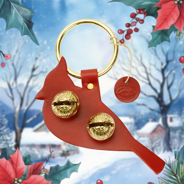 Red cardinal-shaped keychain with gold details on a festive background