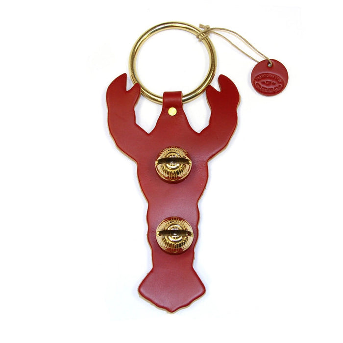 Red lobster-shaped bottle opener with gold accents on a white background