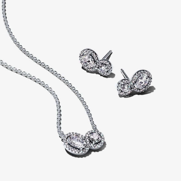 Silver necklace and earrings set on a white background