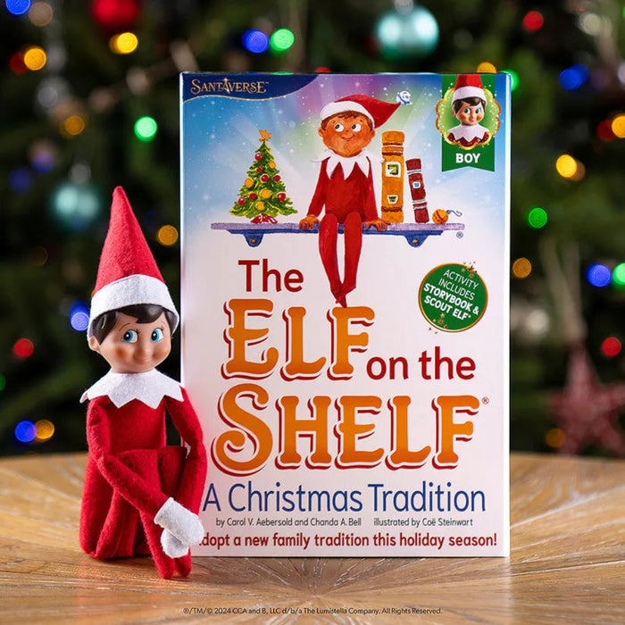 Elf on the Shelf toy with book titled 'The Elf on the Shelf: A Christmas Tradition' against a blurred Christmas tree background.