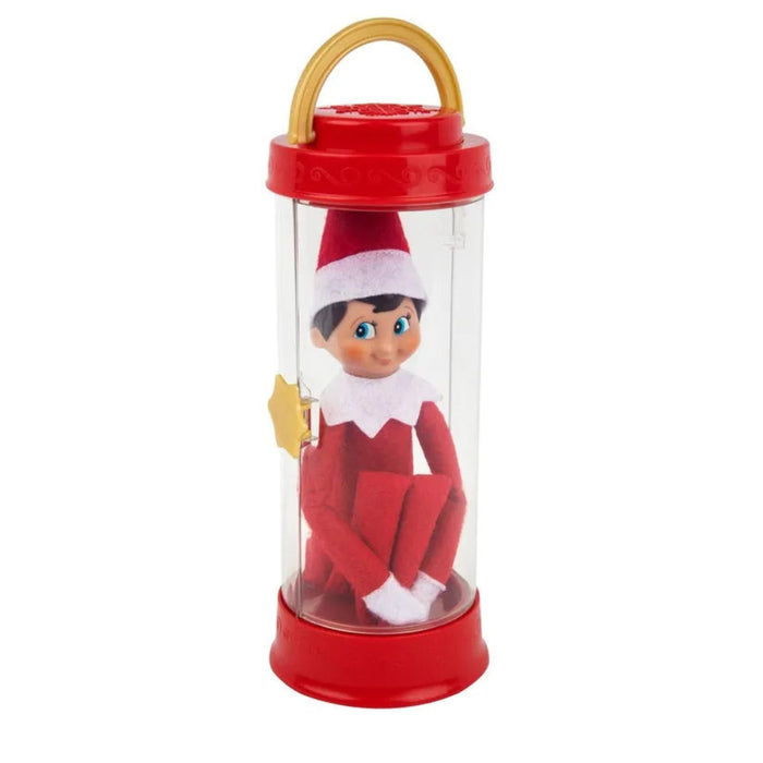 Elf on the Shelf toy in a clear cylindrical container with a red lid and base.