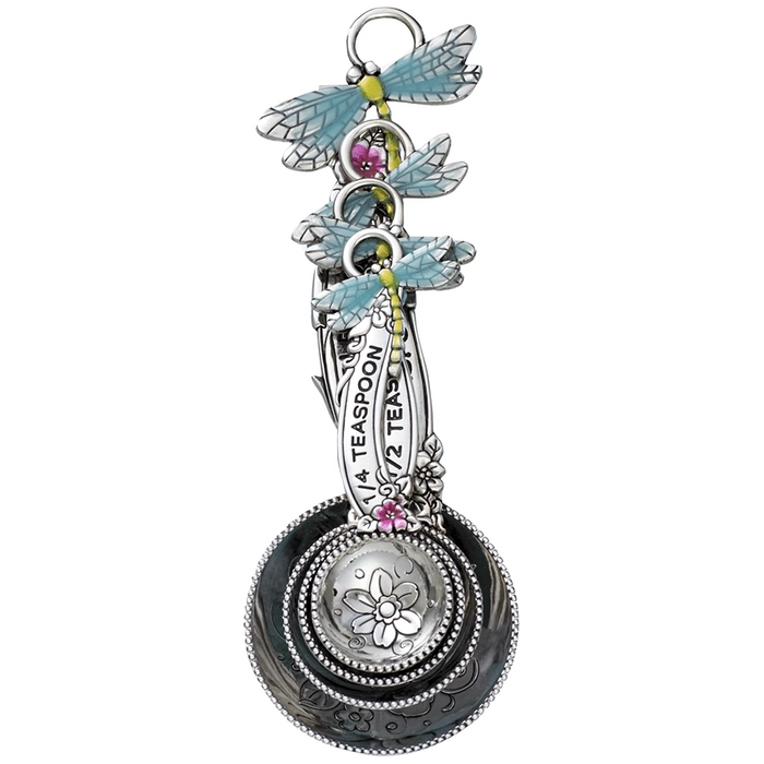 Decorative spoon with dragonfly designs and floral elements on a white background