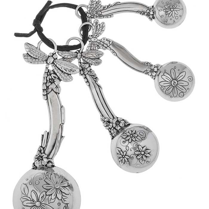 Silver earrings with floral and dragonfly designs on a white background