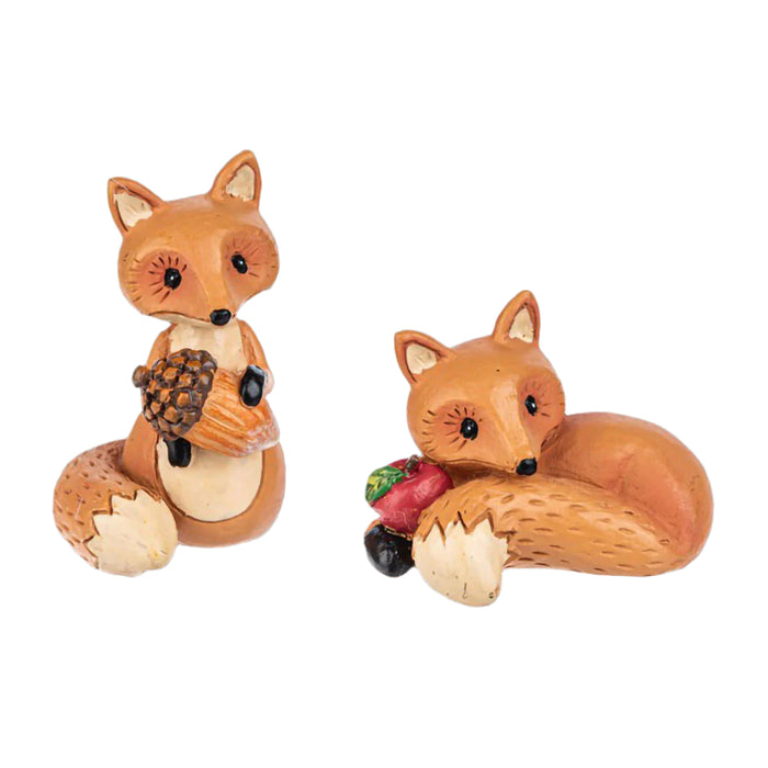 Two fox figurines, one holding acorns and the other with a apple , on a white background. Assorted not choice, one at random 