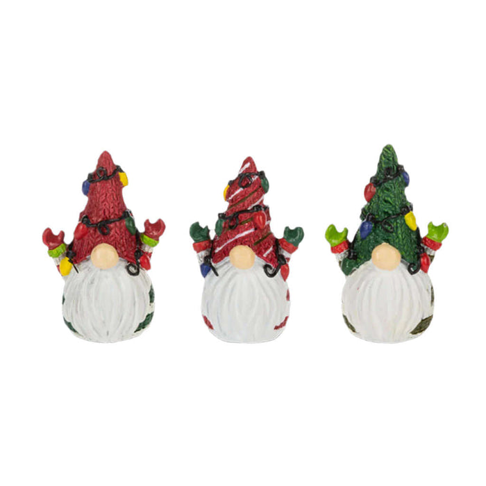 Three decorative gnomes with festive attire on a white background
