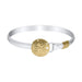 Silver bracelet with a gold sand dollar charm on a white background