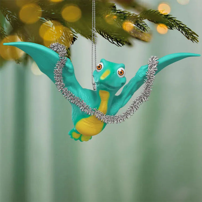 Teal and yellow dragon ornament hanging on a Christmas tree with blurred lights in the background.