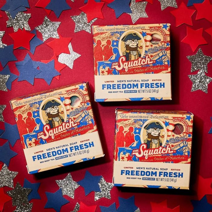 Three boxes of Squatch Freedom Fresh soap on a red background with star and starburst patterns.