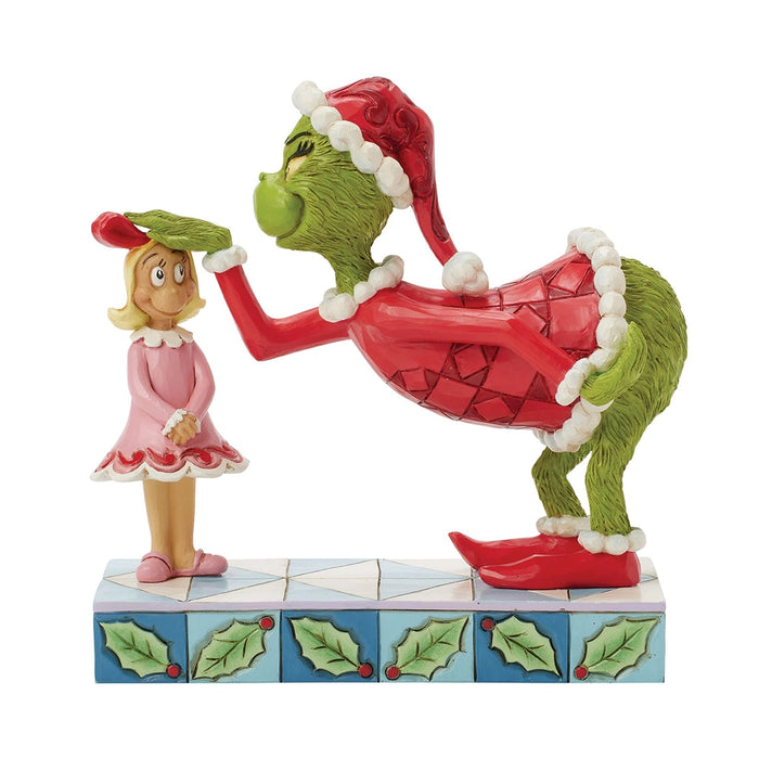 Front view of Jim Shore Grinch figurine patting Cindy Lou’s head, both standing on a holly-patterned base.