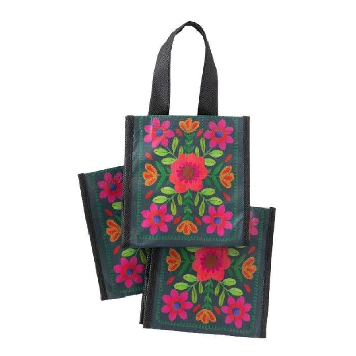 A hand holds a small bag featuring a colorful floral design against a neutral background.