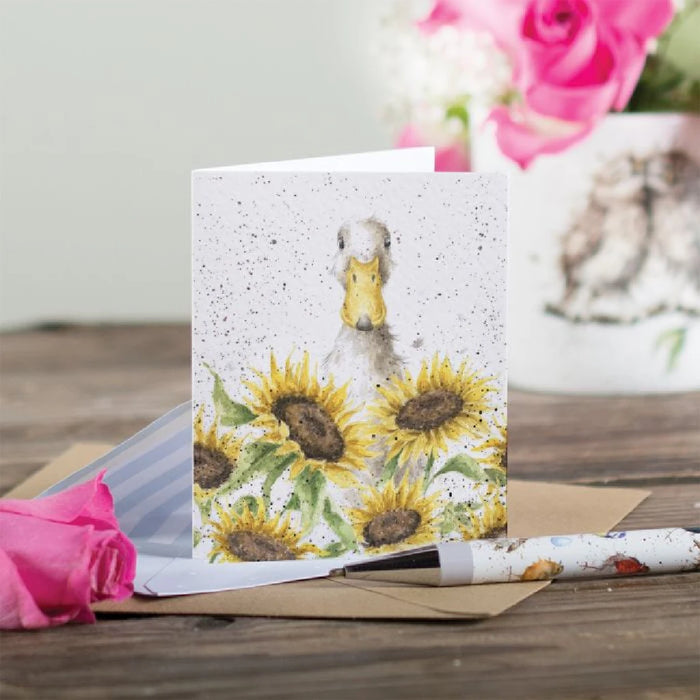 A whimsical greeting card illustrating a duck with bright sunflowers, perfect for sending cheerful wishes.