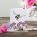A colorful greeting card depicting a bee among blooming tulips, symbolizing spring and nature's beauty.