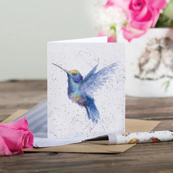 A decorative greeting card showcasing a vibrant hummingbird perched on a branch.