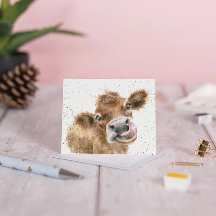 A greeting card displaying a cow's face, showcasing its large eyes and distinctive features.
