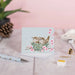 Two sweet birds in a nest illustrated on a greeting card, conveying warmth and friendship.
