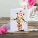 A giraffe sporting a festive birthday hat and a bow tie, adding a playful touch to a celebration.