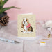 A cheerful birthday card showcasing a basset hound with floppy ears, adorned with a festive party hat and vibrant decorations.
