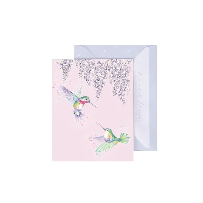 A pink card featuring a detailed illustration of a hummingbird in flight against a soft background.
