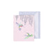 A pink card featuring a detailed illustration of a hummingbird in flight against a soft background.
