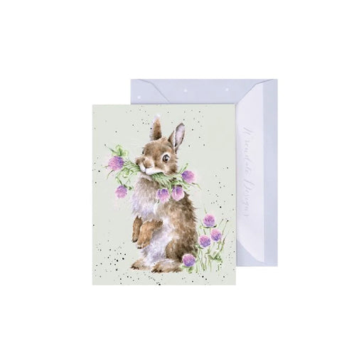 A greeting card featuring a cute bunny surrounded by colorful flowers.