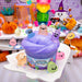 Purple slime in a container with Halloween-themed toys on a colorful background
