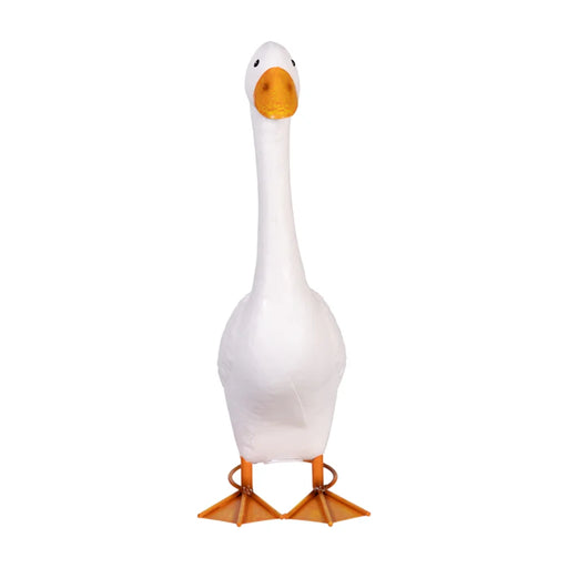  A white goose with an orange beak and orange legs standing on grass.