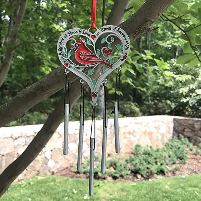 Decorative wind chime with cardinal design hanging from a tree