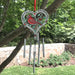 Decorative wind chime with cardinal design hanging from a tree