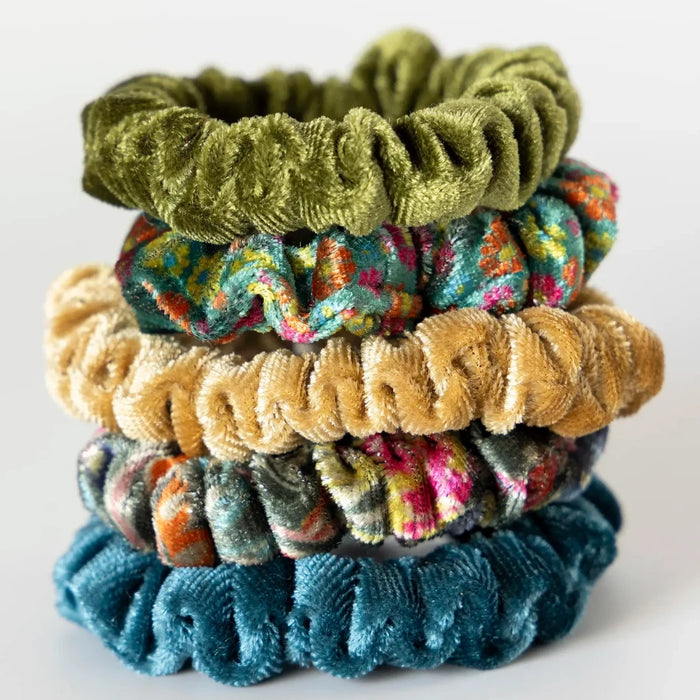 A collection of four scrunchies in different colors arranged on a white background, highlighting their unique styles.