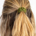 Four distinctively colored scrunchies laid out on a white surface, emphasizing their bright and playful designs.
