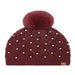 burgundyCheveux Corp beanie with a raised diamond crochet pattern, pearl accents, ribbed cuff, large fluffy ivory pom, and small brown logo patch.