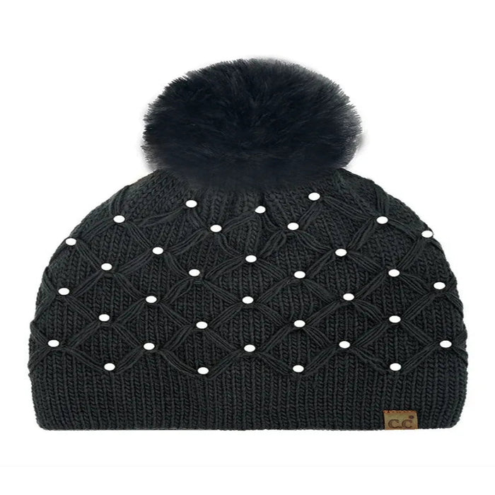 Black Cheveux Corp beanie with a raised diamond crochet pattern, pearl accents, ribbed cuff, large fluffy ivory pom, and small brown logo patch.