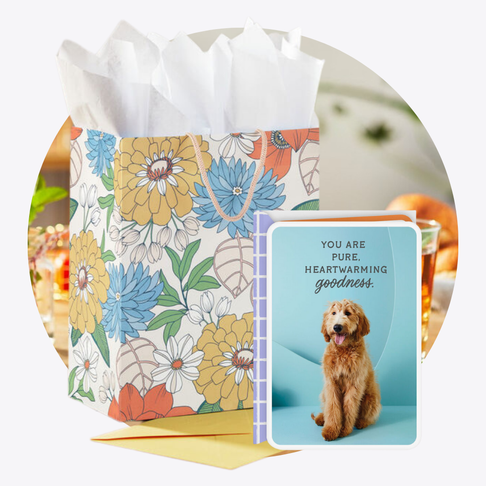 Hallmark Floral-patterned gift bag with a card featuring a dog and text, on a white background.