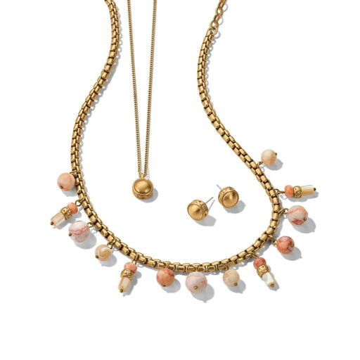 A luxurious gold jewelry set featuring a necklace and earrings, both embellished with vibrant pink stones.