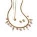 A luxurious gold jewelry set featuring a necklace and earrings, both embellished with vibrant pink stones.