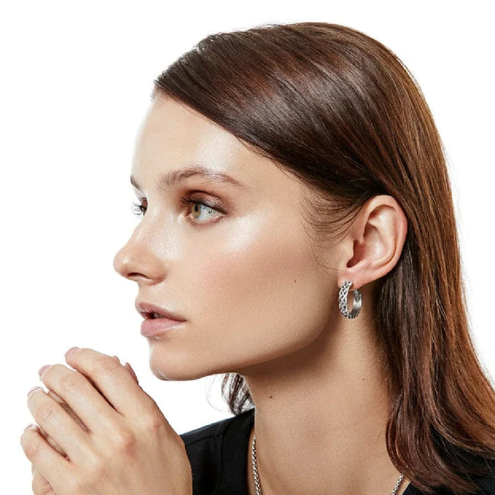 Silver hoop earrings adorned with a delicate braid motif.