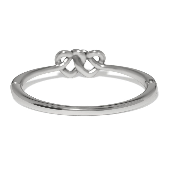 Polished silver Interlok linked hearts hinged bangle featuring intertwined heart motifs with a sleek, elegant design.
