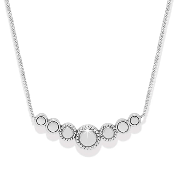 This elegant piece features a slightly curved bar with a petite circular dome at the heart of three stones on either side. A truly precious little treasure, that suspends from a fine delicate chain.