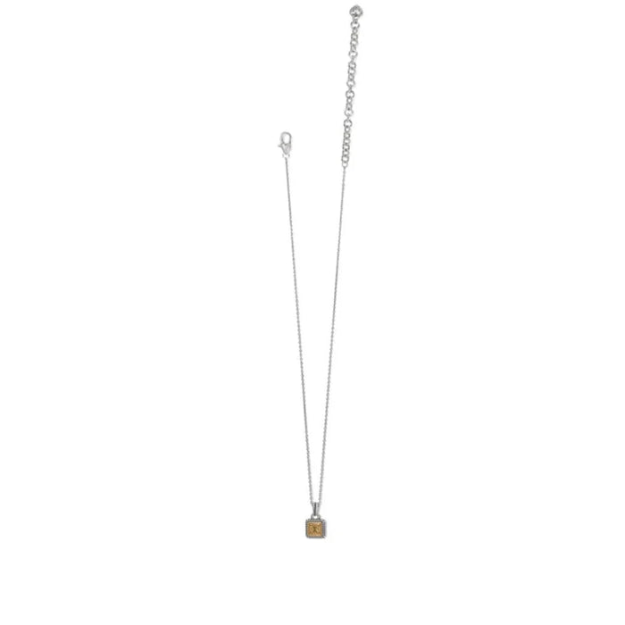 A compact square pendant on a gold and silver chain, representing a refined accessory choice.