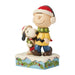 Jim Shore Charlie Brown and Snoopy figurine wearing scarves and Santa hats on snowy base.