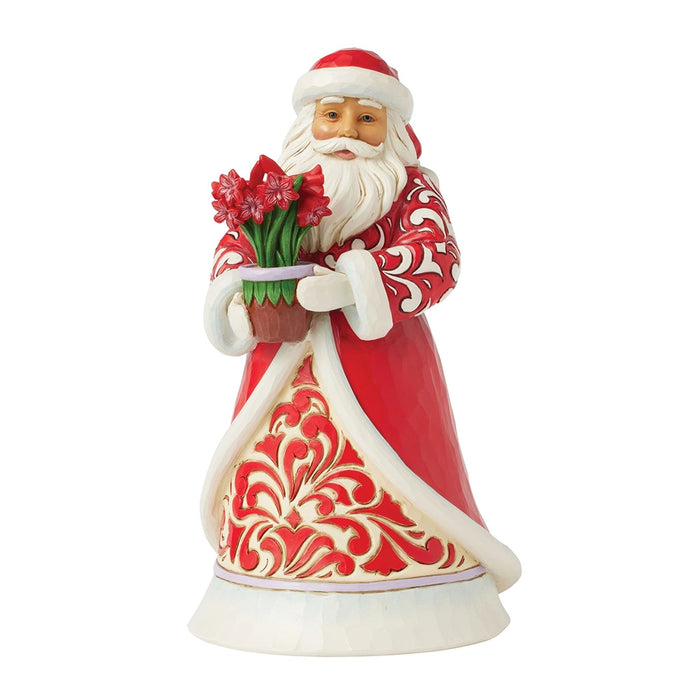Front view of Jim Shore Santa with Blooming Amaryllis figurine in red coat holding flowers.