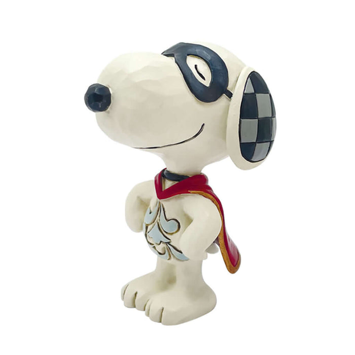 Jim Shore Peanuts mini figurine of Snoopy dressed as a superhero with a red cape and black eye mask, standing proudly on a stack of colorful books against a sky-themed background with clouds and stars