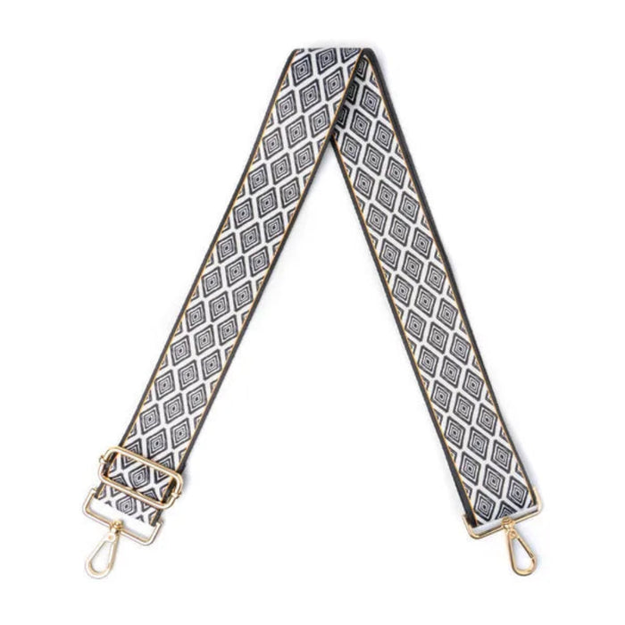 Patterned bag strap with gold hardware on a white background