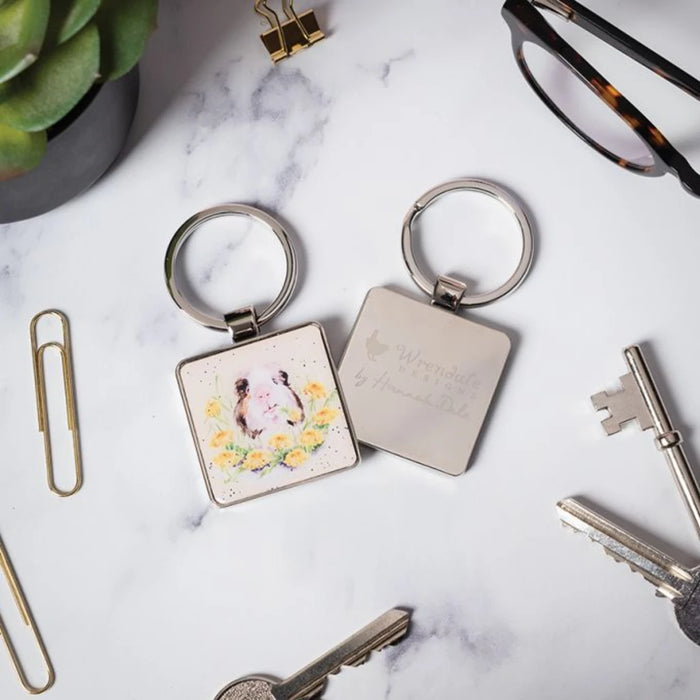 A keyring displaying a guinea pig enjoying sunlight, highlighting its cute features and vibrant colors.