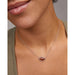 Model wearing Kendra Scott silver football short pendant necklace with orange goldstone charm
