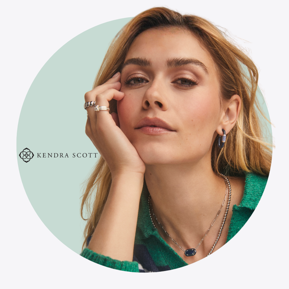 Woman wearing Kendra Scott jewelry with a light green background